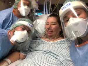 Jan Ehtash lying in a hospital bed with three relatives around her
