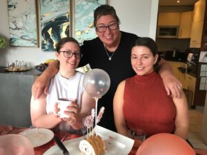 Jan smiles in the middle of her two daughters
