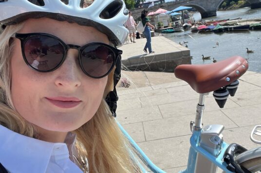 A selfie of Kristina with her bike and wearing a cycling helmet