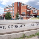A photo of St George's Hospital behind a huge sign that says St George's Hospital