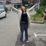 Harriet outside St George's with her arms in the air