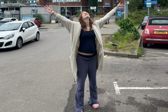Harriet outside St George's with her arms in the air